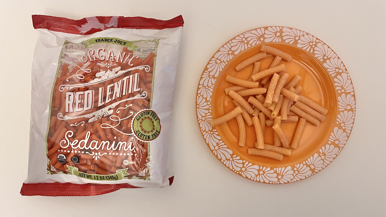 Cooked Organic Red Lentil Sedanini pasta from Trader Joe's next to a whole bag of uncooked pasta