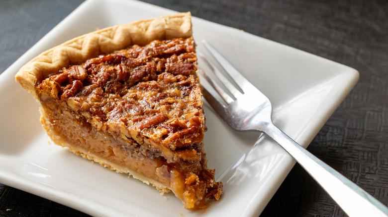Slice of pecan pie on plate with fork