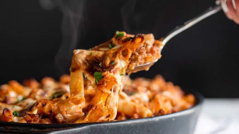 Baked ziti being served with a spoon