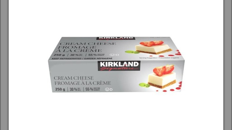 Silver box of Kirkland Signature cream cheese, with cheesecake slice pictured on package