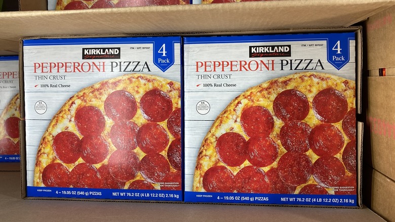 Two boxes of Kirkland Signature frozen pepperoni pizza side by side in larger cardboard box
