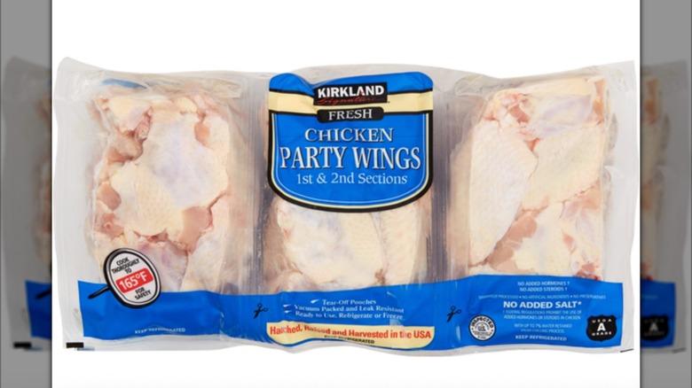 Close-up of three-pack of Kirkland Signature party raw chicken wings with blue packaging