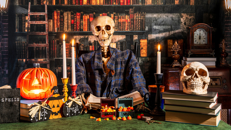 Skeleton sat at desk surrounded by Halloween decorations