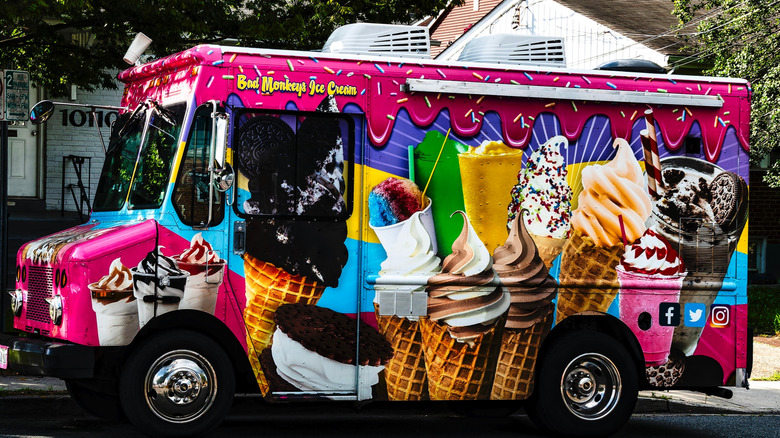 Colorful pink ice cream truck with ice cream cone graphics