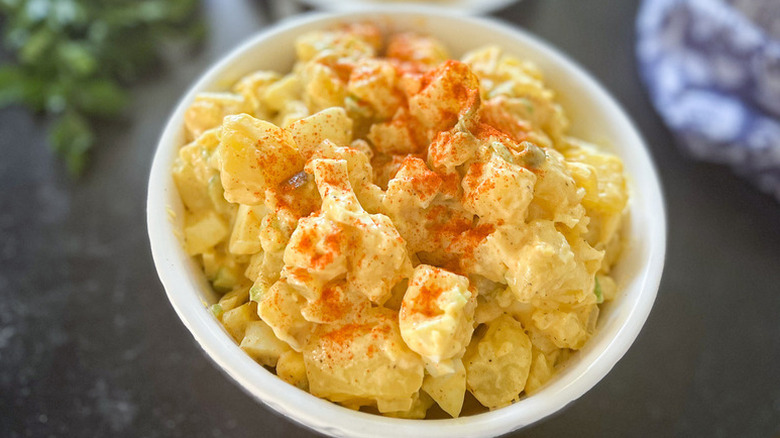 Bowl of creamy potato salad garnished with paprika