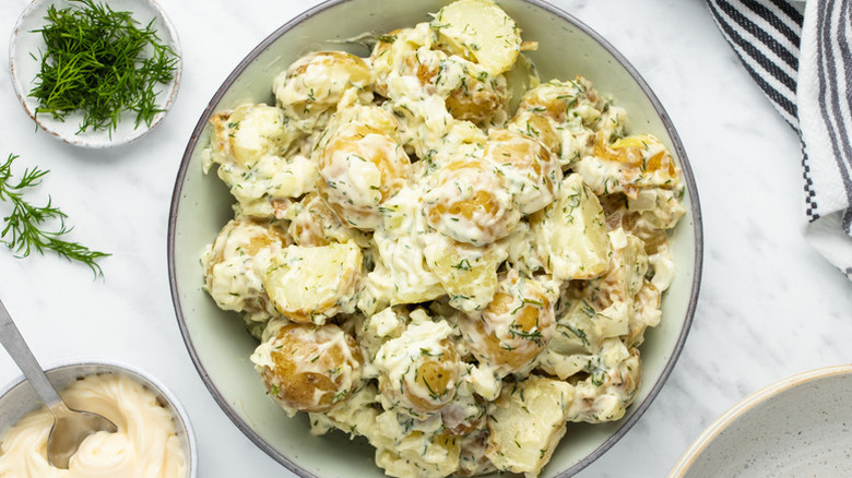 Bowl of creamy potato salad with fresh dill