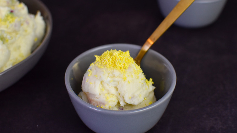 Korean potato salad in small bowl, topped with grated egg yolks