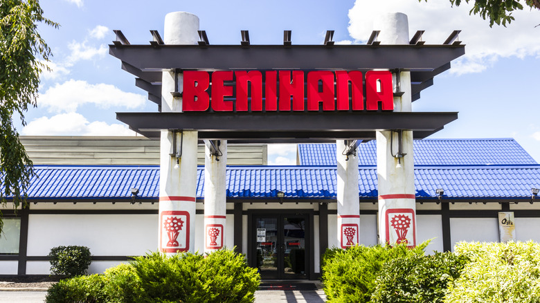 A wide view of a large Benihana restaurant with its sign showcased on tall pillars
