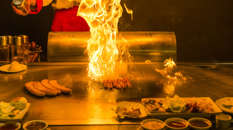 A person cooking food teppanyaki-style, which became popular in America