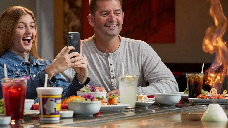 Two diners marveling at one of Benihana's classic cooking tricks
