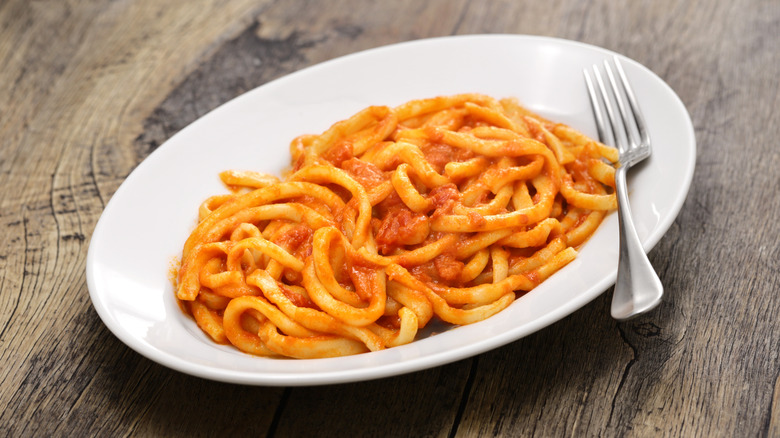 white dish of pici all'aglione on table