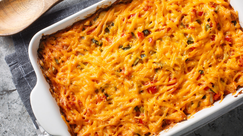 A tray of King Ranch casserole covered with melted, grated cheese