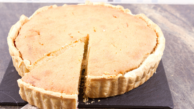 A Marlborough pie with a slice cut out on a black slate