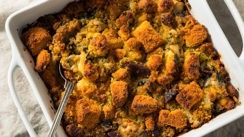 A dish of oyster stuffing with a spoon