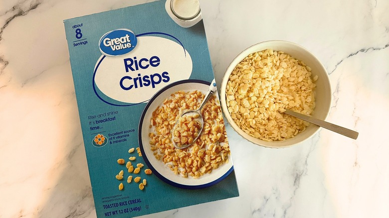Box of Great Value Rice Crisps cereal next to bowl of cereal with spoon on marble surface
