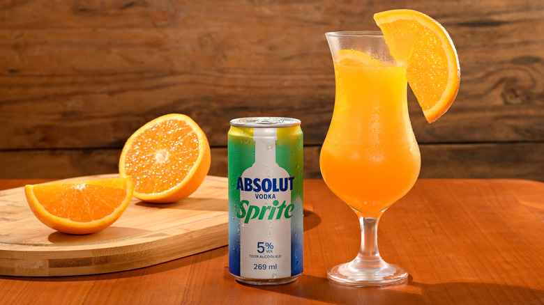 Absolut vodka and Sprite can with orange juice