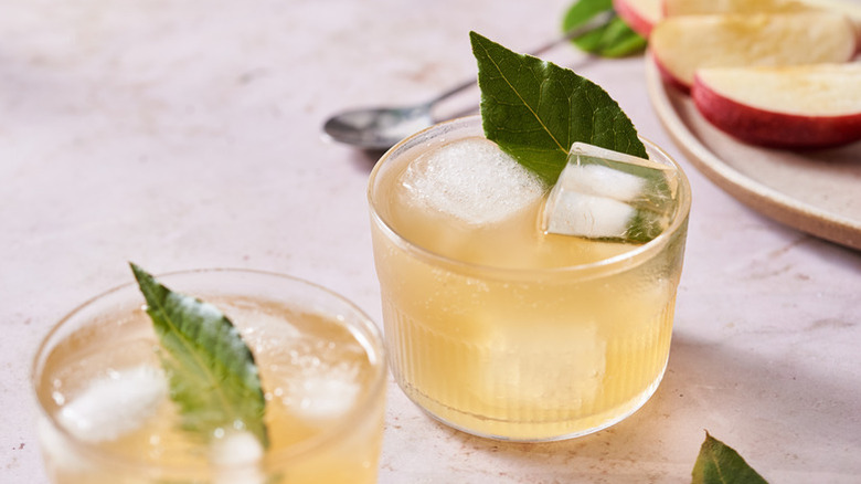 Miso cider cocktails in glasses with ice cubes and bay leaves