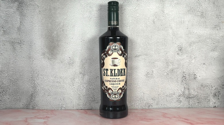 Bottle of St. Elder Natural Espresso Coffee Liqueur on grey wall background