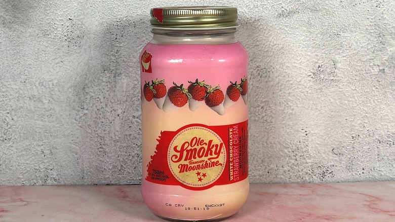 Bottle of Ole Smoky White Chocolate Strawberry Cream Moonshine on grey wall background