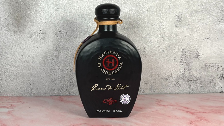 Bottle of Hacienda de Chihuahua Crema de Sotol on grey wall background