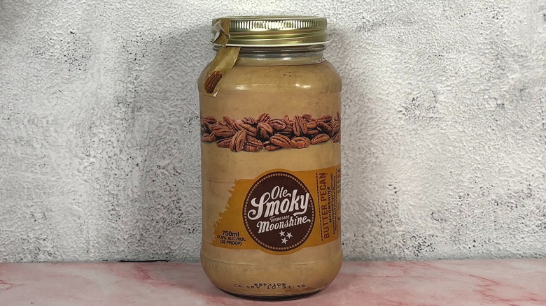 Bottle of Ole Smoky Butter Pecan Moonshine on grey wall background