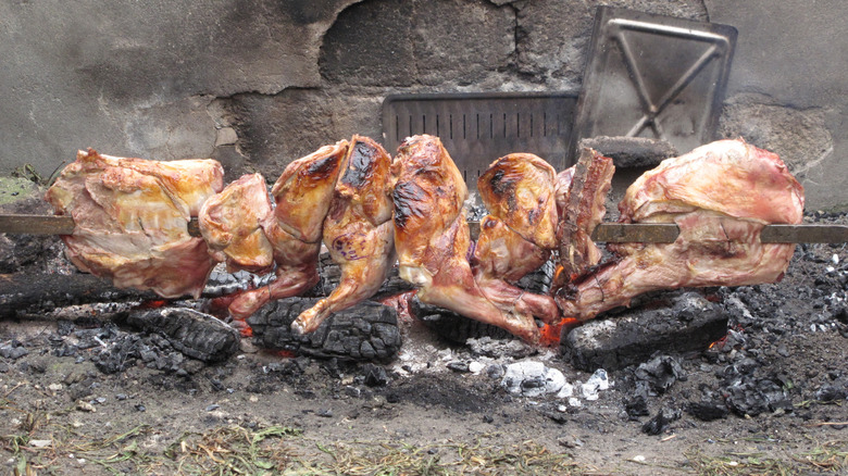 Lamb cooking on a spit over burning coals
