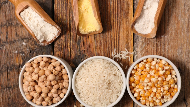 Three bowls and three wooden scoops full of alternative flours and their ingredients