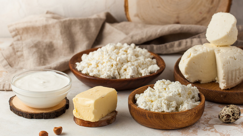 Assorted dairy products on a rustic wooden set up with cloth in the background