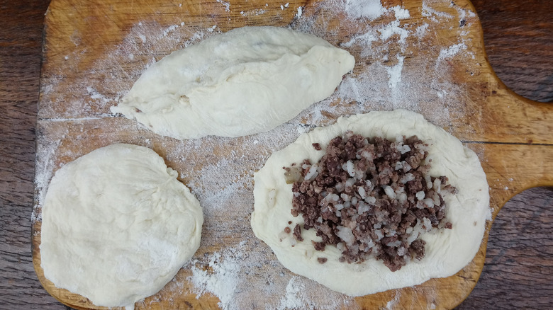 Raw dought and mincemeat pie filling on a wooden cuttingboard