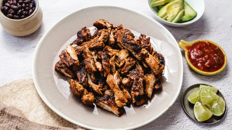 Copycat Chipotle Honey Chicken on a white plate with all sides and garnishes on the side