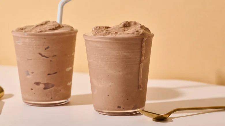 Two glasses of copycat Wendy's Chocolate Frosty against an orange background