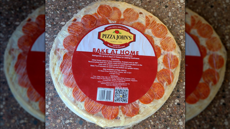 a Pizza John's bake at home pizza, shown in its wrapping on a stone countertop