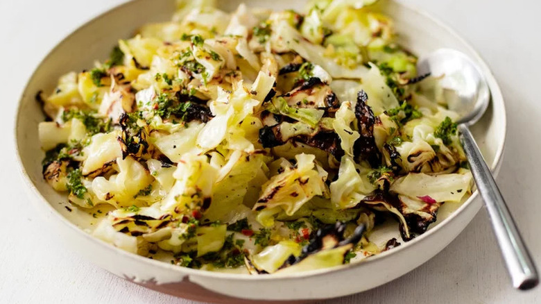 Grilled Cabbage in white bowl with silver spoon