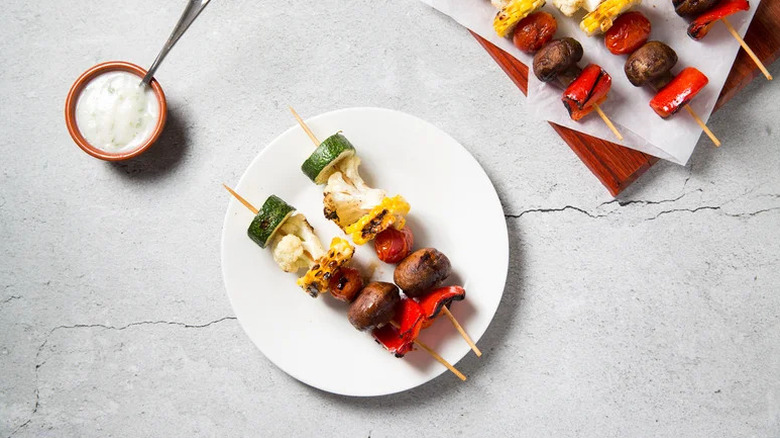 Grilled Veggie Skewers with Herby Yogurt Sauce on white plate