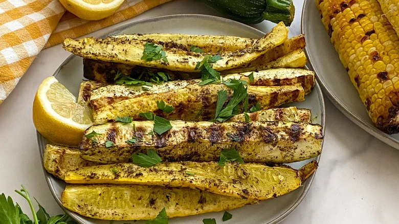 Marinated Grilled Summer Squash on beige plate with lemon wedge