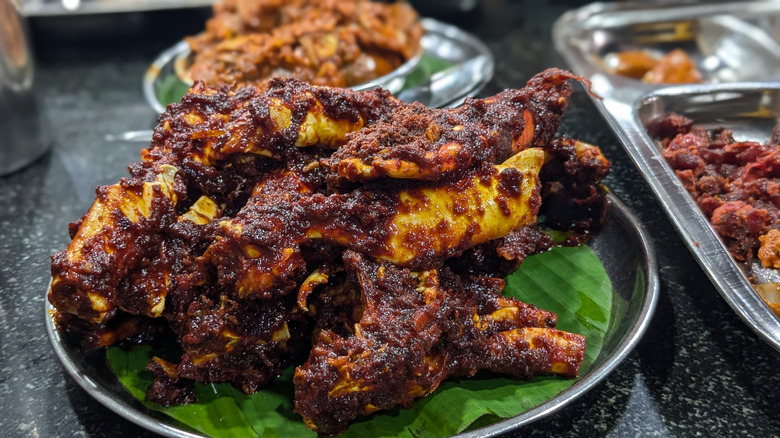 Crab ghee roast served atop banana leaf on plate