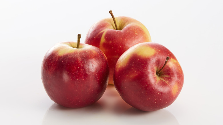 Three red apples on white background