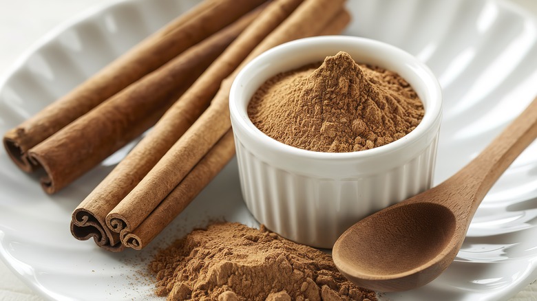 Cinnamon sticks and powder on white plate