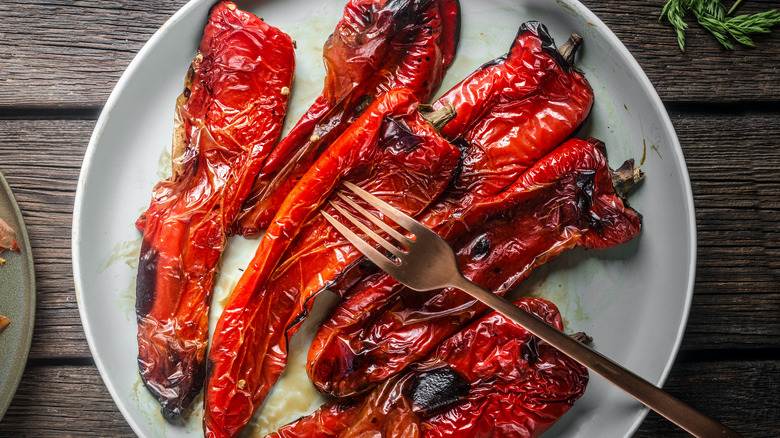 Roasted red peppers on white plate with fork