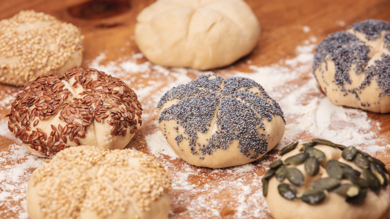 Unbaked brötchen topped with various seeds
