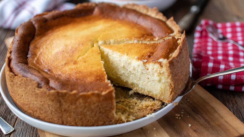Käsekuchen being served from dish on wooden platter