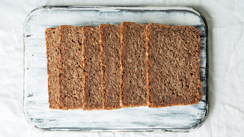 Close up of four pumpernickel slices on white board