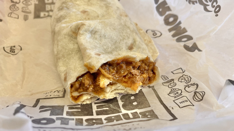 Beef burrito with cheese on paper wrapper