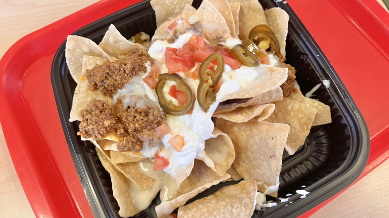 Side view of queso loaded beef nachos with sour cream