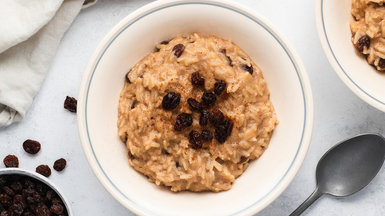 Spiced rice pudding in bowl, topped with raisins