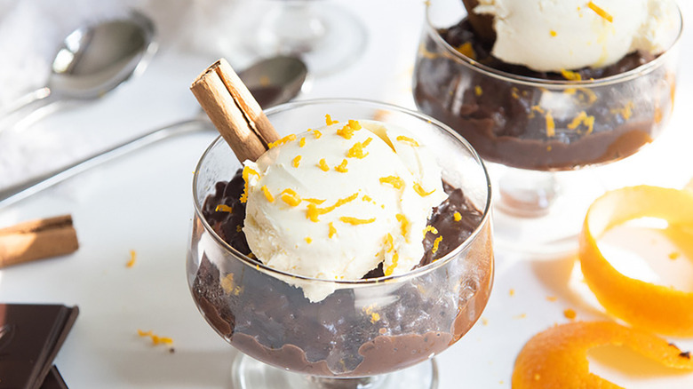 Chocolate orange risotto in serving glass with whipped cream and orange zest