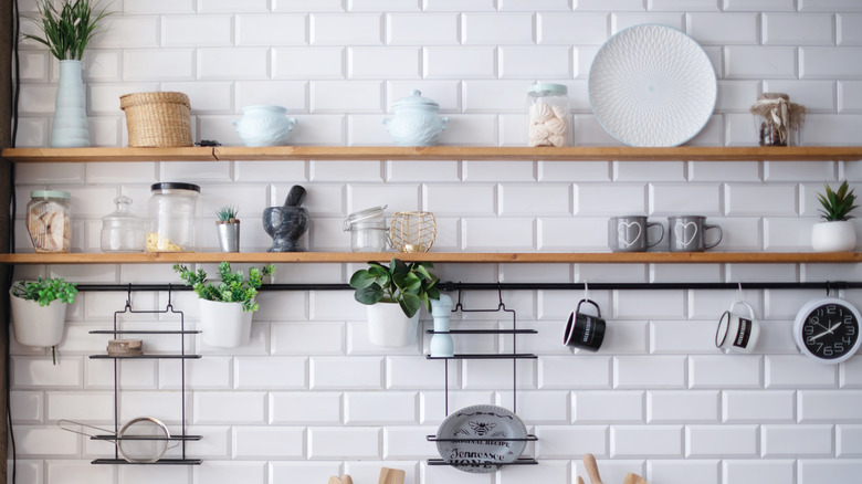 Two long, wooden shelves holding various kitchen supplies.