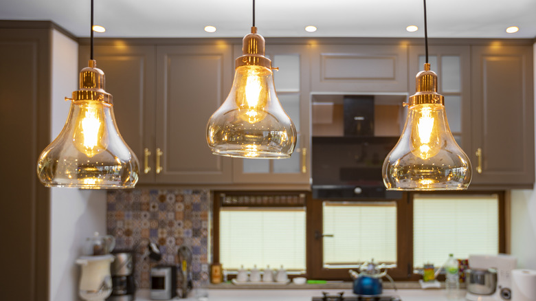 Three teardrop-shaped glass lights hanging in a kitchen.