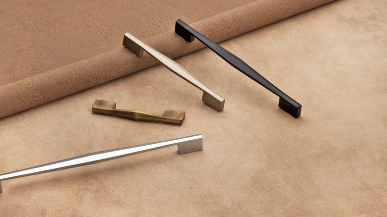 Four metallic handles for kitchen cabinets and drawers.