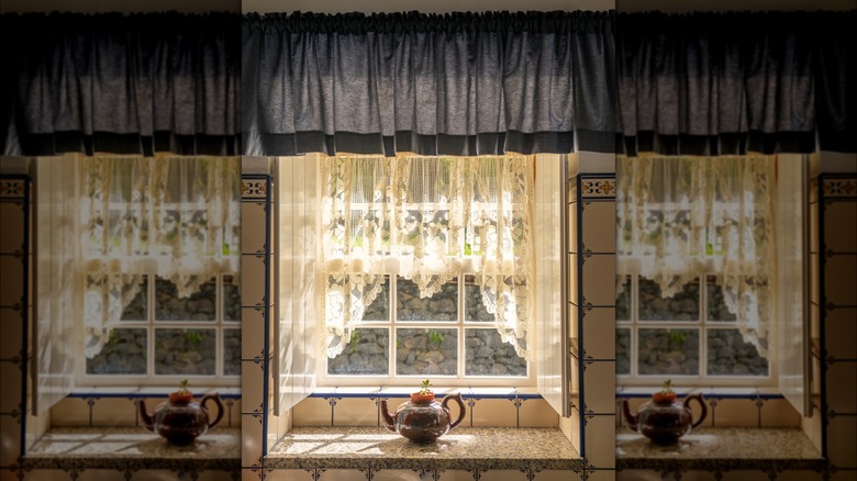kitchen window with blue and white curtains and a teapot planter in the center.